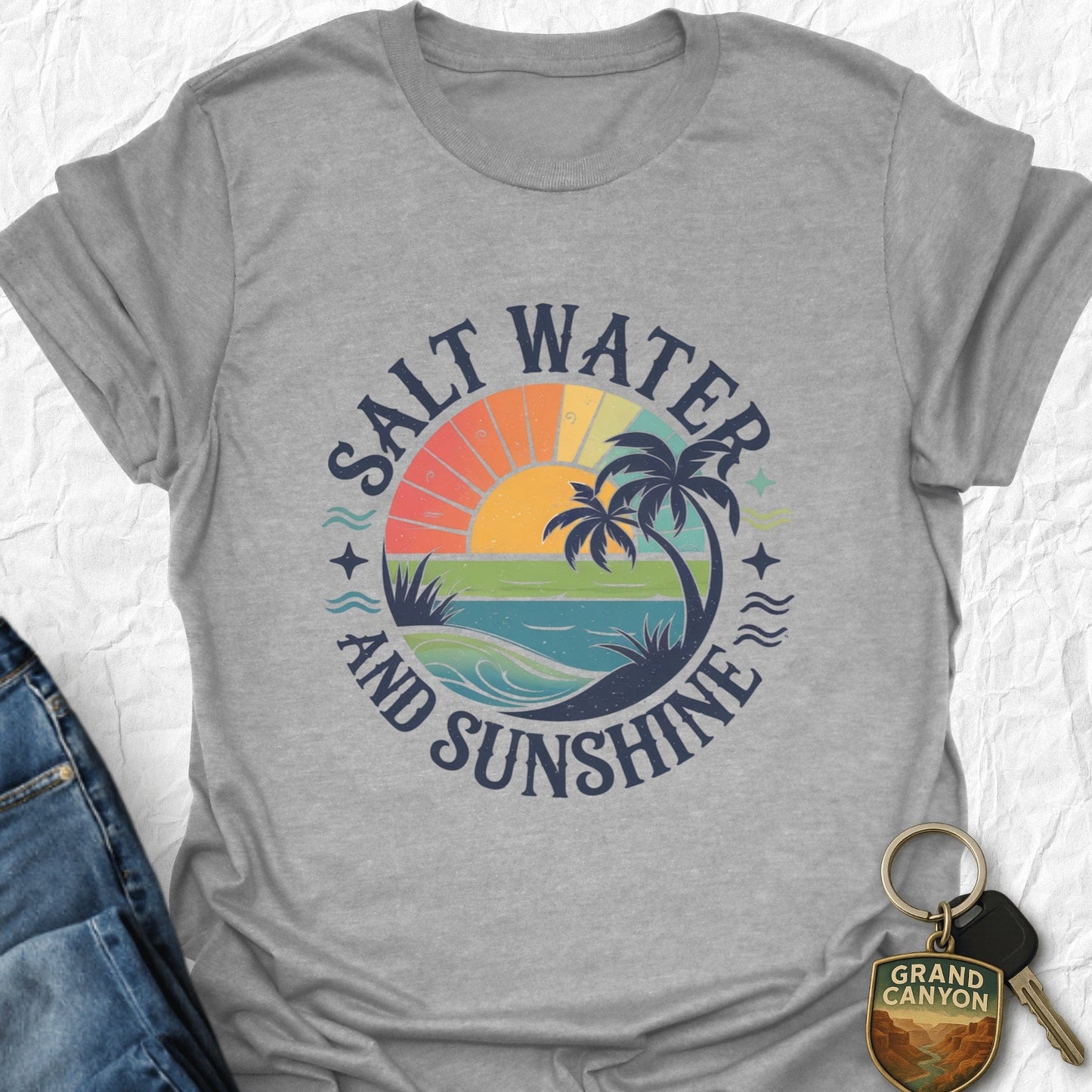 Gray t-shirt with 'Salt Water and Sunshine' graphic design on a textured white background.
