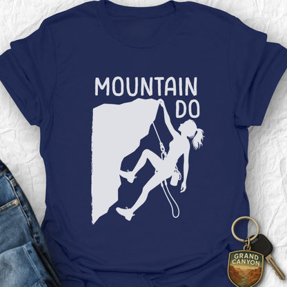Navy blue t-shirt with mountain climbing graphic and 'Mountain Do' text on a textured surface.