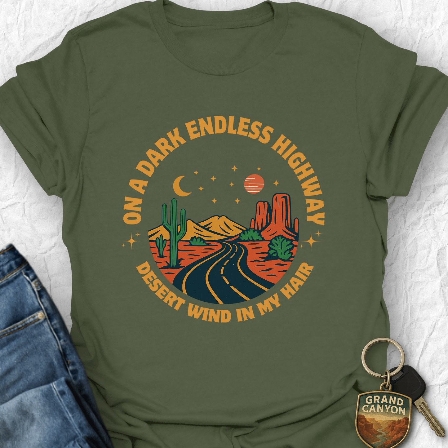 Green t-shirt with desert-themed graphic and text on a white background