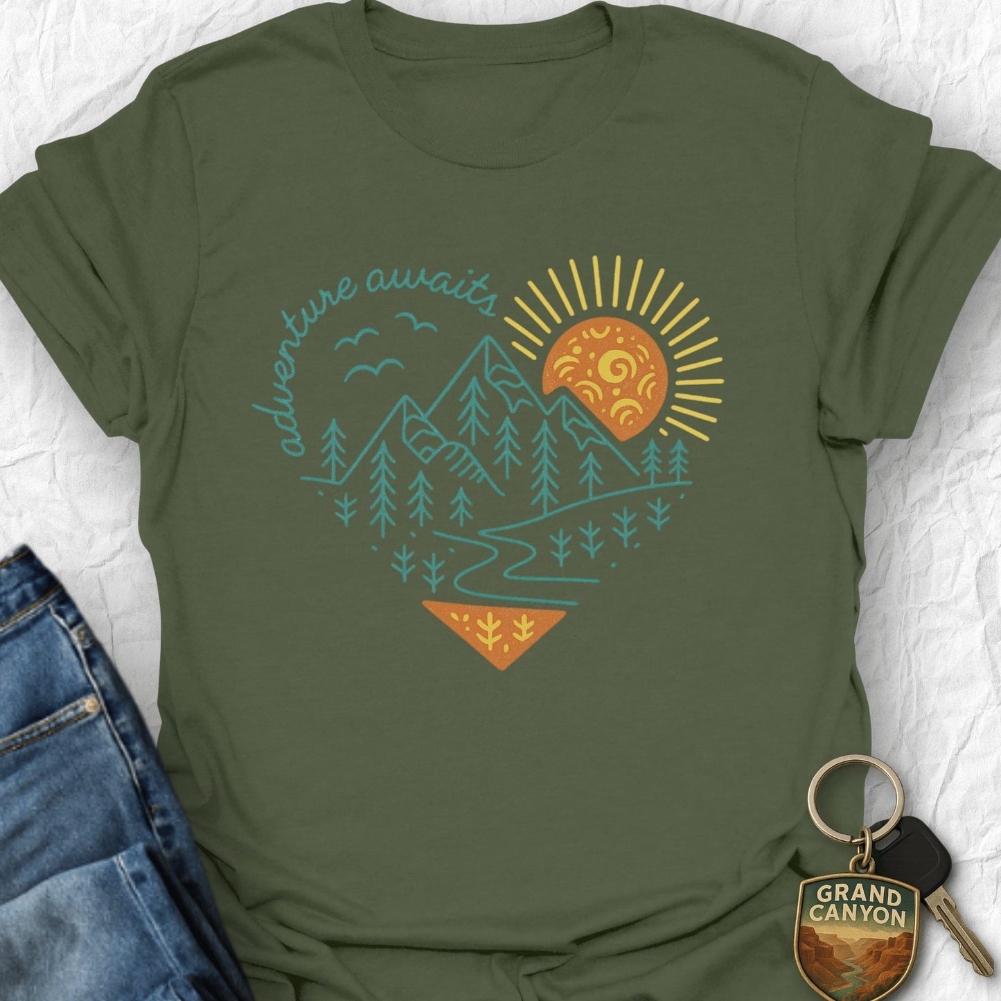 Green t-shirt with 'adventure awaits' graphic on a white background