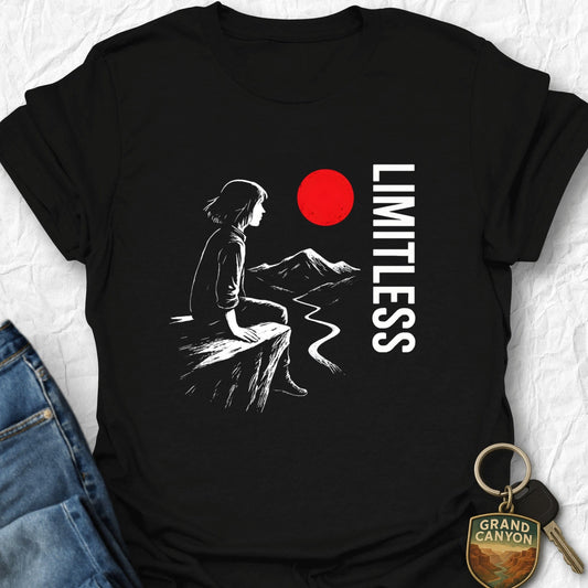 Black t-shirt with a graphic of a person sitting, mountains, and a red circle with 'LIMITLESS' text on a white background.