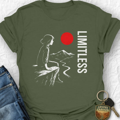 Green t-shirt with a graphic of a person sitting, mountains, and a red circle with 'LIMITLESS' text on a white background.