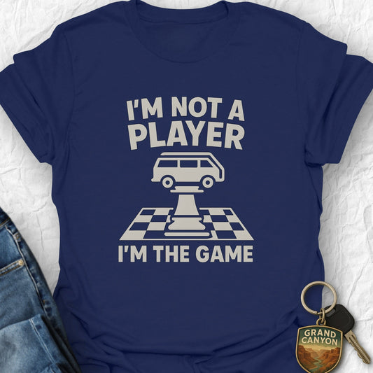 Navy blue t-shirt with white text and graphic, placed on a light gray surface with jeans and keys.