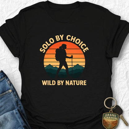 Black t-shirt with 'Solo by choice, wild by nature' design featuring a hiker silhouette against a sunset background.