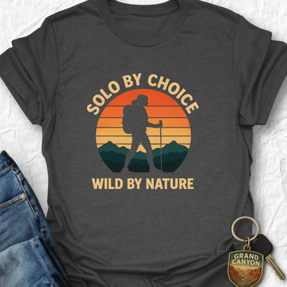 Dark gray t-shirt with 'Solo by choice, wild by nature' design on a textured white background.