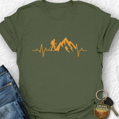 Green t-shirt with orange graphic design featuring a hiker, mountains, and heartbeat line on a white background.
