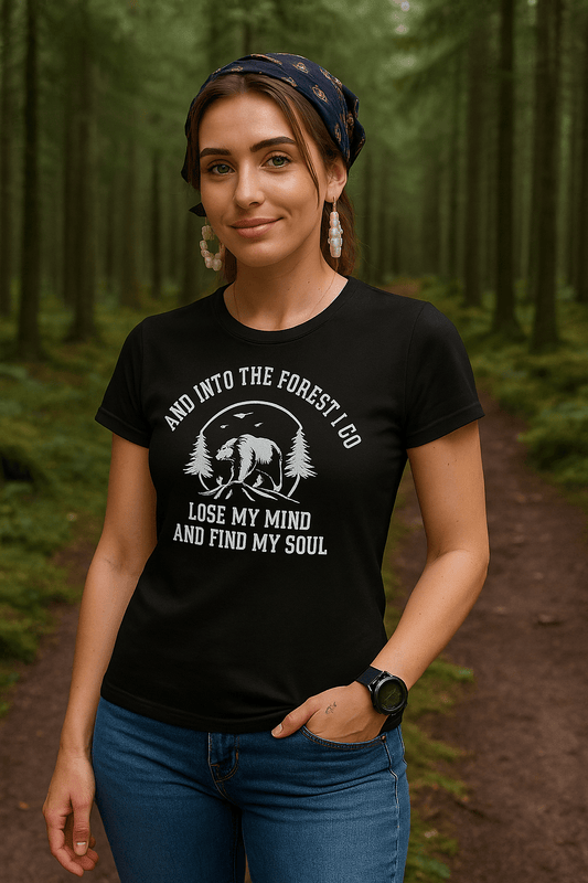 Woman wearing a black t-shirt with a forest design and text in a forest setting