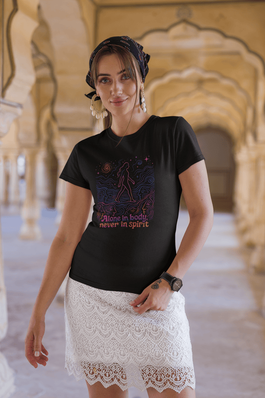 Woman wearing a black t-shirt with colorful design and text in an architectural setting