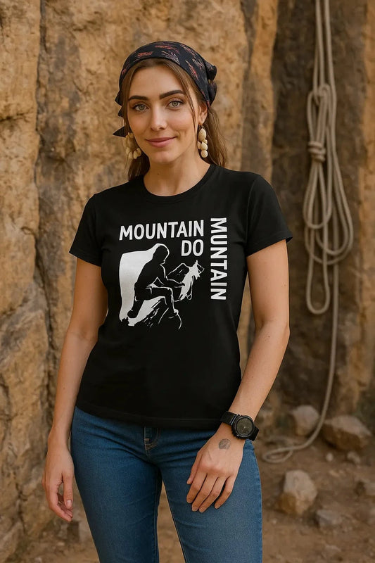 Woman wearing a black t-shirt with mountain climbing graphic and text, standing against a rocky wall.