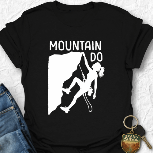 Black t-shirt with mountain climbing graphic and 'Mountain Do' text on a textured surface.